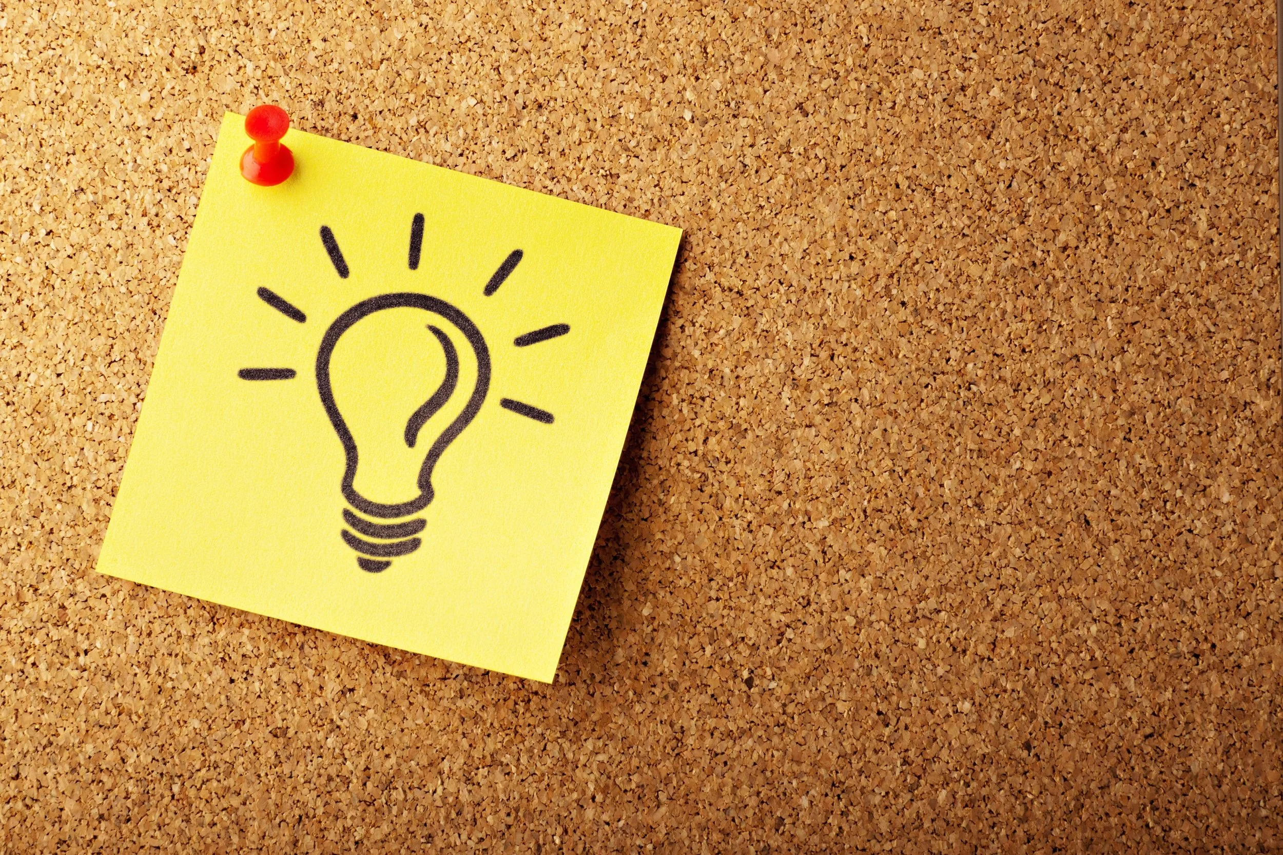  Light bulb drawn on sticky note hung on cork board.  